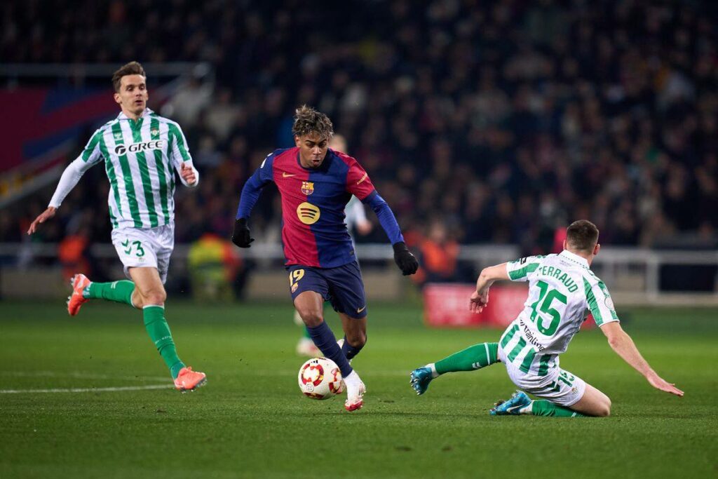 Lamine Yamal dribbles past Betis defenders