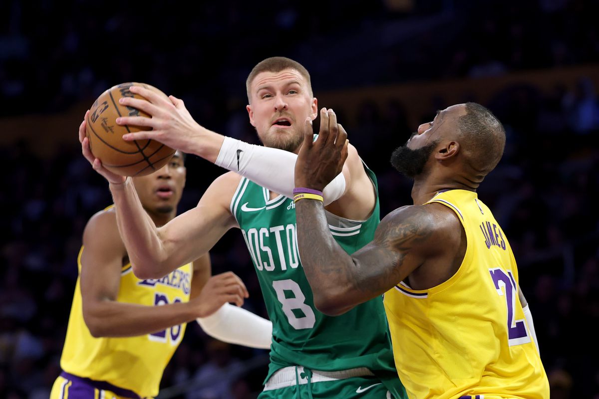 Kristaps Porzingis with the ball defended by LeBron James