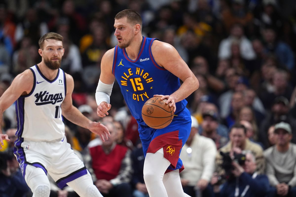 Nikola Jokic dribbles the ball with Domantas Sabonis watching