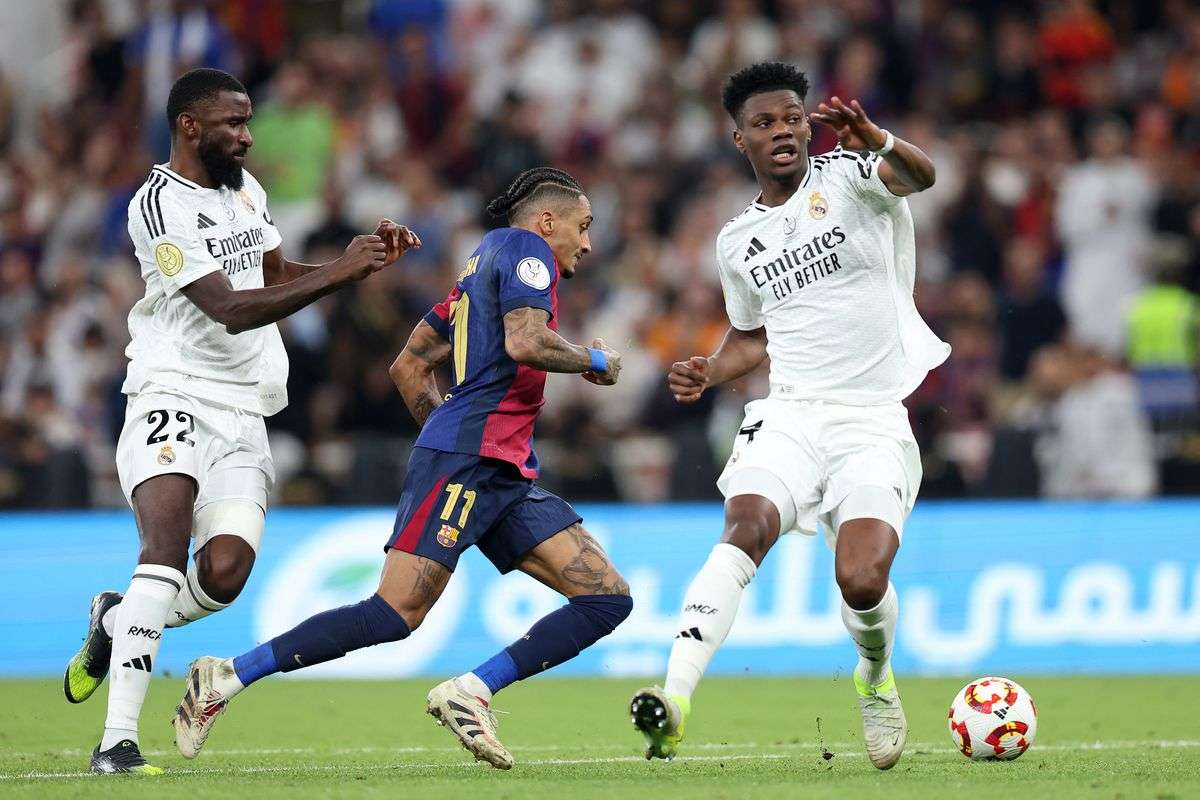 Raphina dribbles past Aurelien Tchouameni and Antonio Rudiger