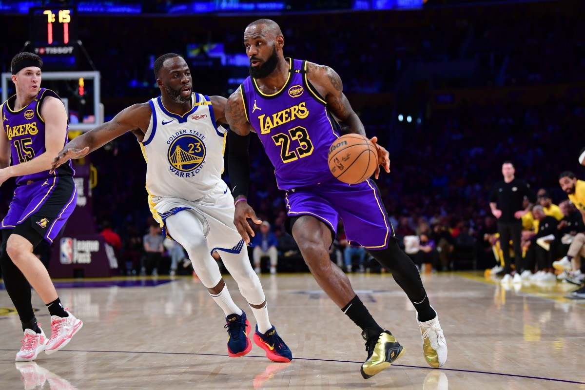 LeBron James attacks the basket guarded by Draymond Green