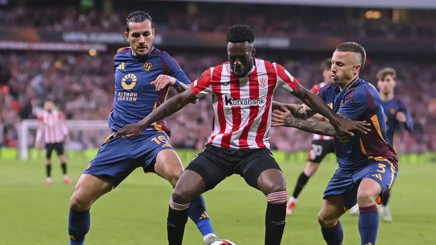 Inaki Williams protects the ball from 2 Roma players