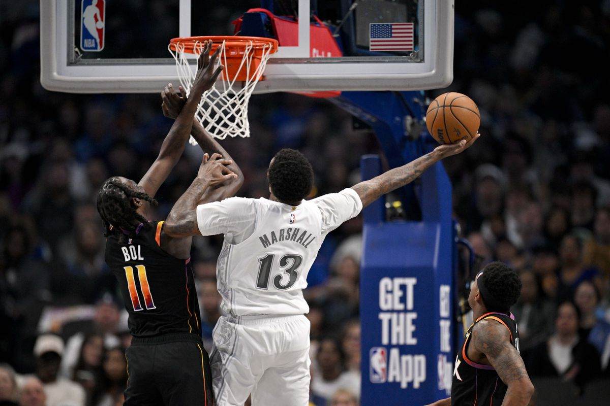 Nadji Marshall trying to score in Phoenix' basket. despite Bol Bol's attempts to stop him