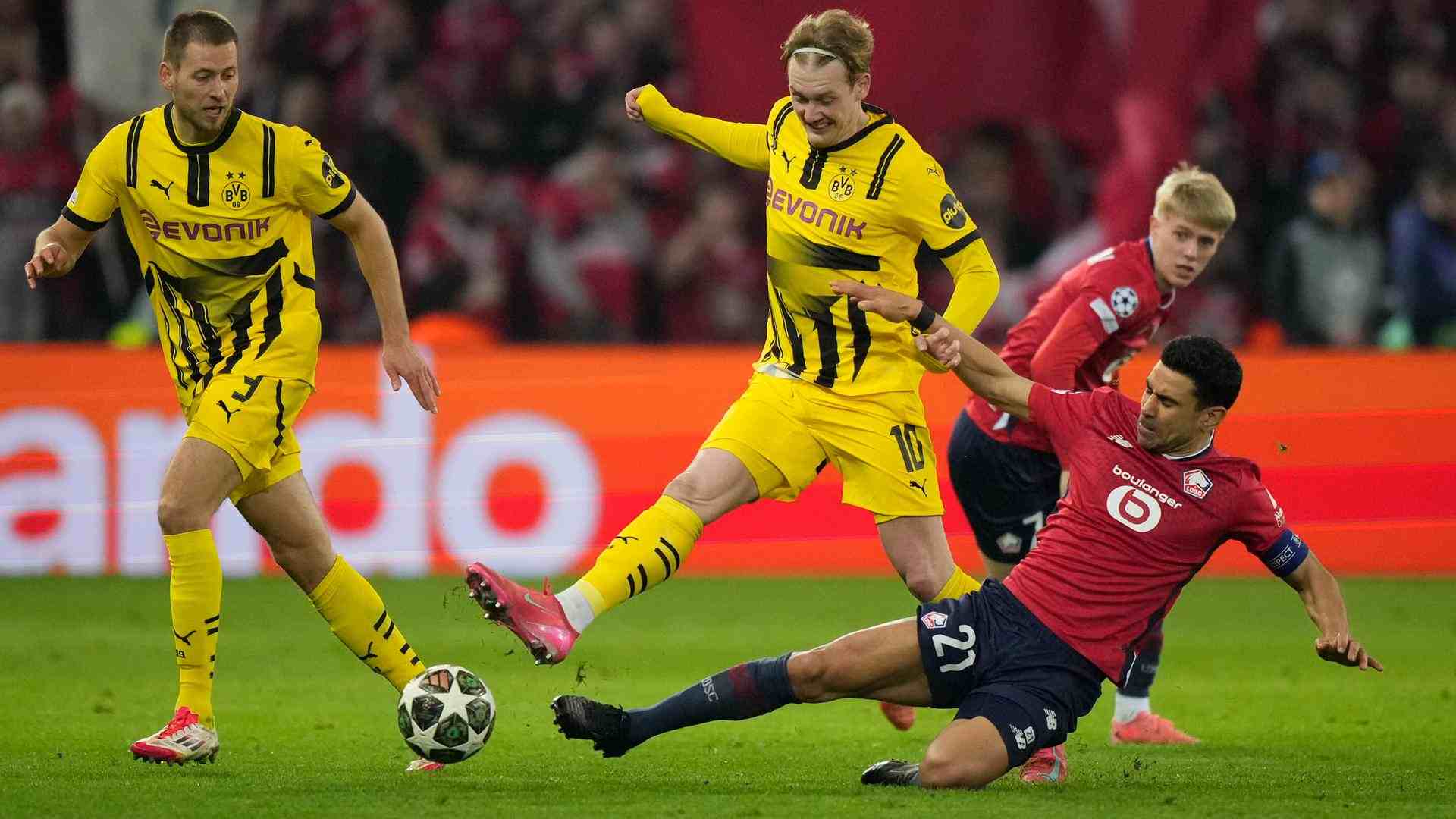 Julian Brandt trying to evade a tackle from a Lille player