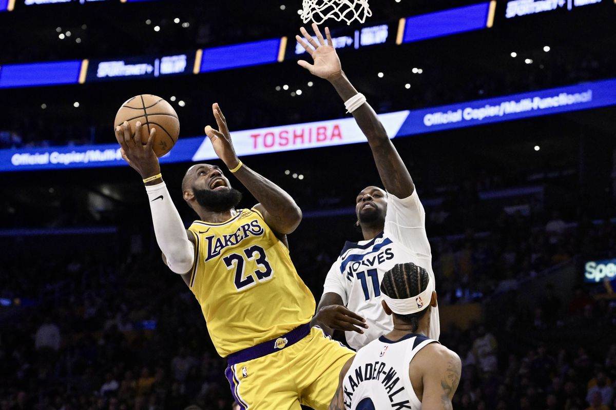 LeBron James attempting a lay-up despite guarded by 2 Minnesota players